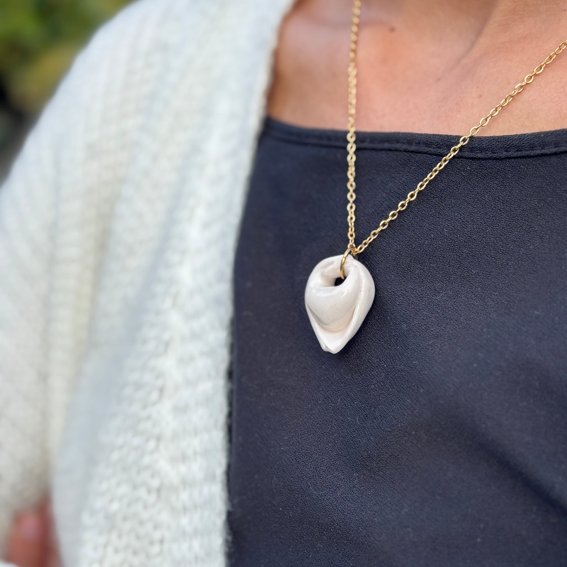 Handcrafted white ceramic tortellino pendant on a gold stainless steel chain banceramiche 